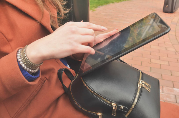 A woman uses a black tablet - Foto, afbeelding
