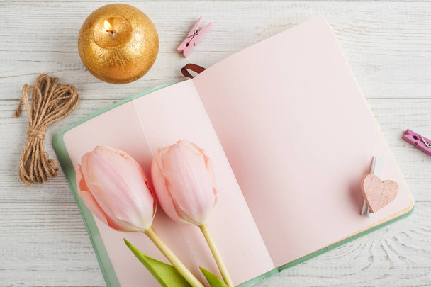 Taccuino rosa, tulipani e candela accesa
 - Foto, immagini