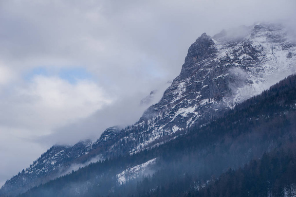 Темний, оманливий гірський пейзаж з вершинами, зануреними в хмари і туманні ліси
 - Фото, зображення