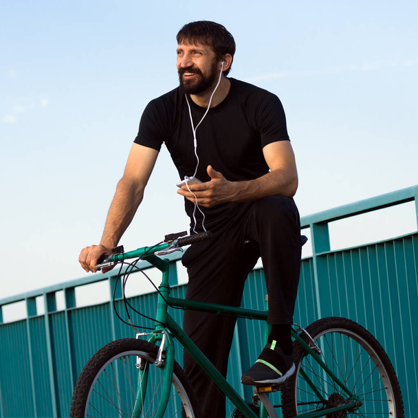 ciclista sonriente usando el teléfono
 - Foto, Imagen