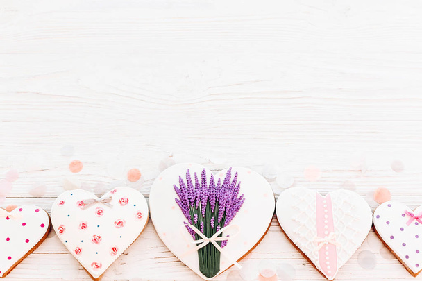 Eväste sydämet laventeli kukkia valkoinen maalaismainen puinen tausta konfetti tasainen lay. tilaa tekstille. Hyvää äitienpäivää onnittelukortti. onnellista ystävänpäivää tai naisten
 - Valokuva, kuva