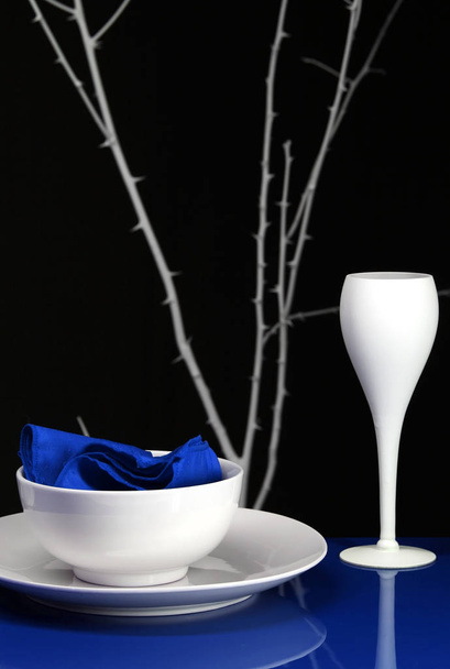 Un juego de mesa para la cena con plato y copa de vino en azul - Foto, Imagen