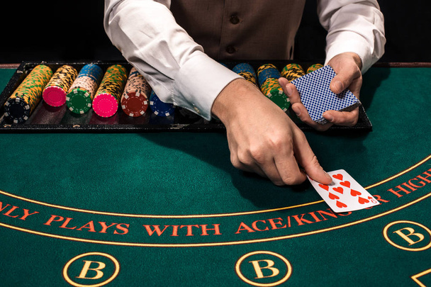 Close up de revendedor holdem com cartas de baralho e fichas na mesa verde
 - Foto, Imagem