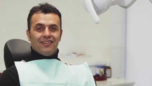 glücklicher älterer Mann lächelt und hält einen Apfel im Zahnarztstuhl - Filmmaterial, Video