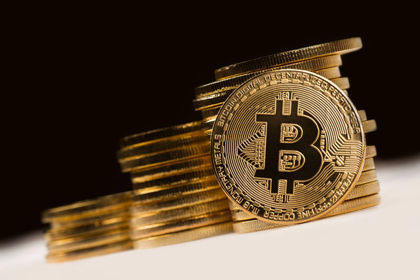 bitcoin dourado na frente de uma pilha de moedas metálicas douradas em bl
 - Foto, Imagem