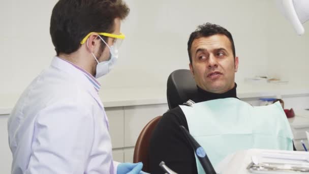 Dojrzały mężczyzna, odwiedzając jego dentysta w klinice - Materiał filmowy, wideo