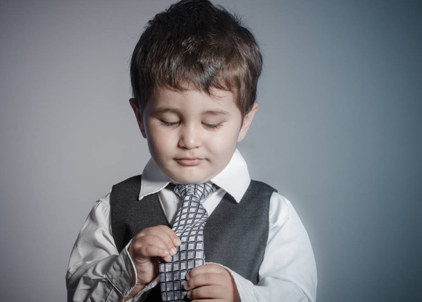 first employment, little businessman, brown-haired boy dressed in suit and tie with faces and funny expression - Foto, Imagem