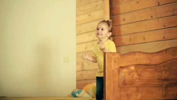 Szczęśliwy skok. Dziecko jest skakanie na łóżko w drewnianym domu. Dobre dzieciństwo i rozwoju fizycznego, radości i zabawy, sukces i świętowania. Szczęście dla małym chłopcem stylowe z długimi włosami - Materiał filmowy, wideo