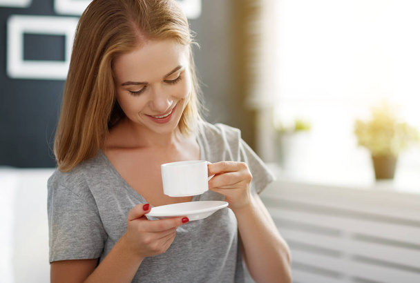 happy young woman with cup of morning coffee in bed - Foto, Imagem