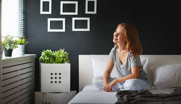 fiatal nő ébredt fel reggel a hálószobában által a windo - Fotó, kép