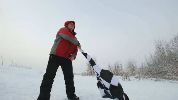Mann schwenkt Zielflagge im Winter - Filmmaterial, Video