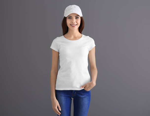 Beautiful young woman in stylish white t-shirt on grey background. Mockup for design - 写真・画像