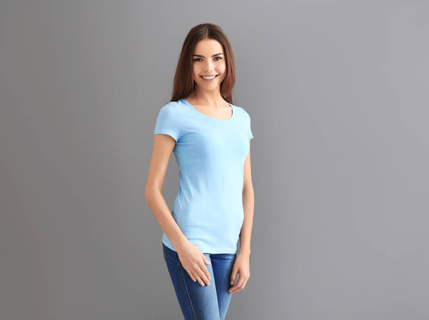 Beautiful young woman in stylish t-shirt on grey background. Mockup for design - Foto, Imagem