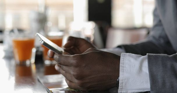 Black businessman male hands using smart phone touchscreen in cafe - Fotografie, Obrázek