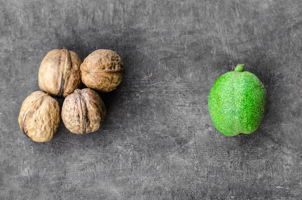 четыре текстурированных очищенных грецких ореха в куче и один зеленый
 - Фото, изображение