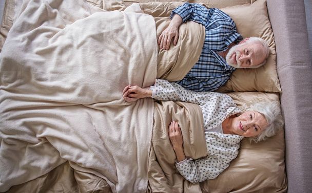 Calm senior couple waking up in the morning - 写真・画像