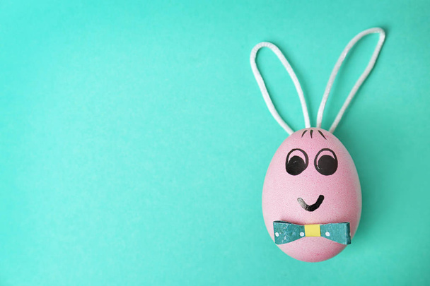 Easter egg decorated with bunny ears on color background - Foto, Bild