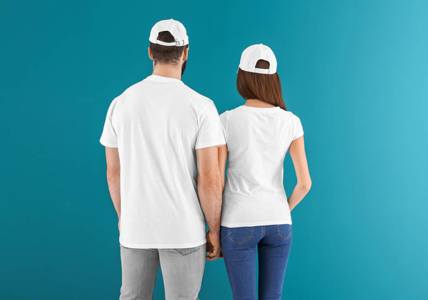 junge Männer und Frauen in stilvollen weißen T-Shirts auf farbigem Hintergrund. Design-Attrappe - Foto, Bild