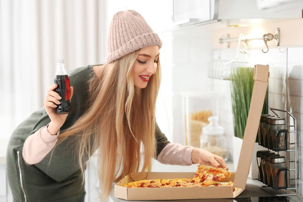 Vonzó csípő lány ízletes pizza és egy üveg kóla beltéri - Fotó, kép