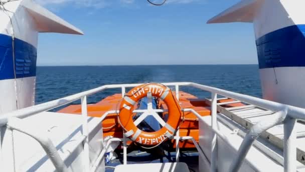Um navio branco com uma boia salva-vidas em sua popa se move no mar
 - Filmagem, Vídeo