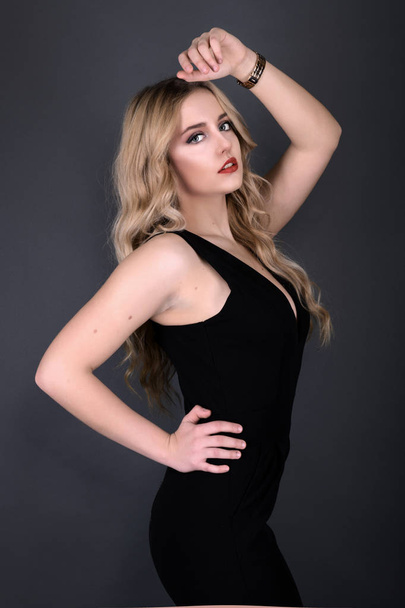 Blonde girl with long and volume shiny wavy hair . Beautiful woman model with curly hairstyle . - Zdjęcie, obraz