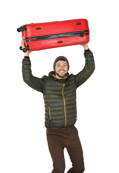 Young man in warm clothing with luggage on white background. Ready for winter vacation - Photo, Image