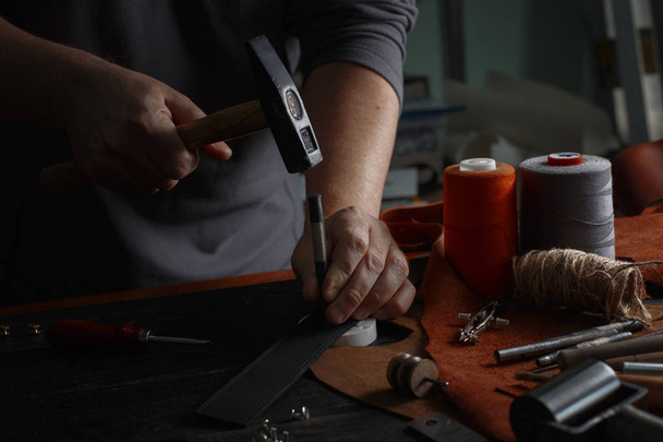 Man working with leather using crafting DIY tools - 写真・画像
