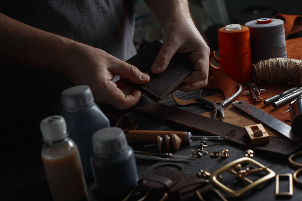 Hombre trabajando con cuero usando herramientas de bricolaje artesanales
 - Foto, imagen
