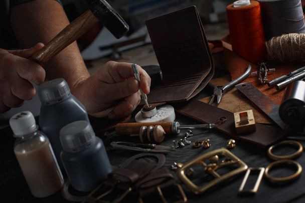 Mies työskentelee nahkaa käyttäen käsityökaluja DIY työkaluja
 - Valokuva, kuva