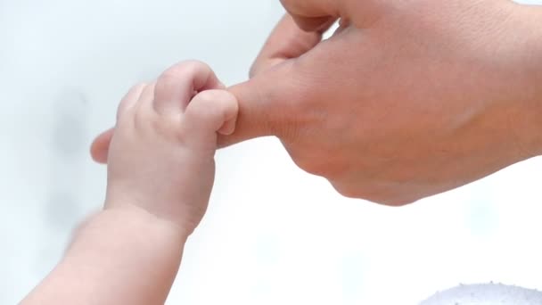 Dítě drží prst matky doma, zpomalené detailní pohled - Záběry, video