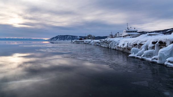 Ice-covered pier in the Baikal port village - 写真・画像