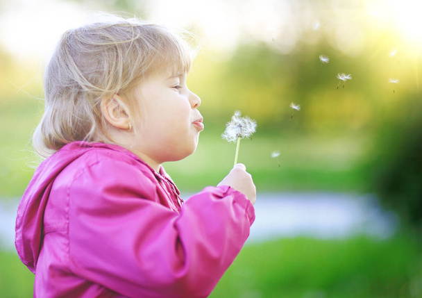 Cute child blow dandelion outdoor - Photo, Image