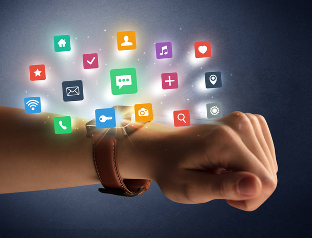 Female hand wearing smartwatch with app icons - Photo, Image