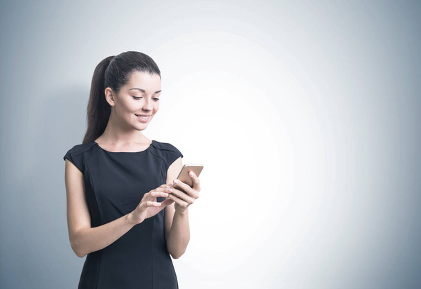 Businesswoman with a smartphone, gray - Φωτογραφία, εικόνα