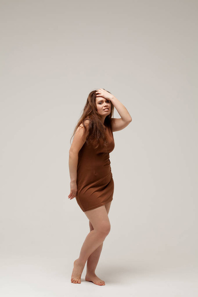 Plus size fashion model in brown short dress - Zdjęcie, obraz