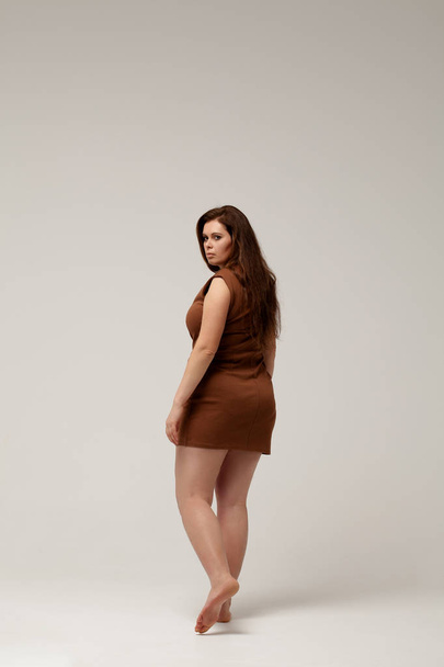 Plus size fashion model in brown short dress - Фото, зображення