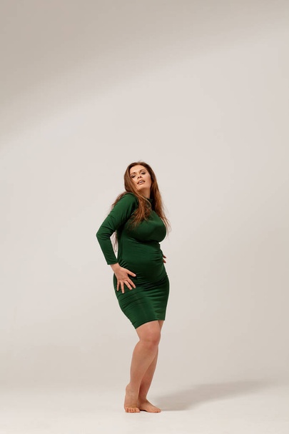 Beautiful large girl isolated in green dress - 写真・画像