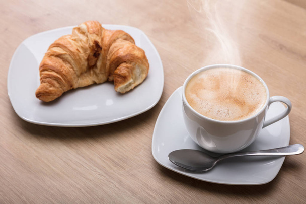 Croissant And Cup Of Hot Coffee On Wooden Desk At Breakfast - Zdjęcie, obraz