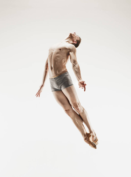 The male athletic ballet dancer performing dance isolated on white background. - Fotó, kép