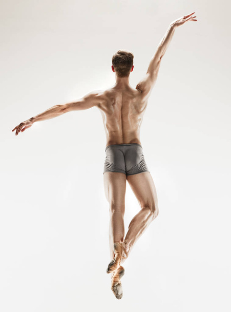 The male athletic ballet dancer performing dance isolated on white background. - Фото, зображення