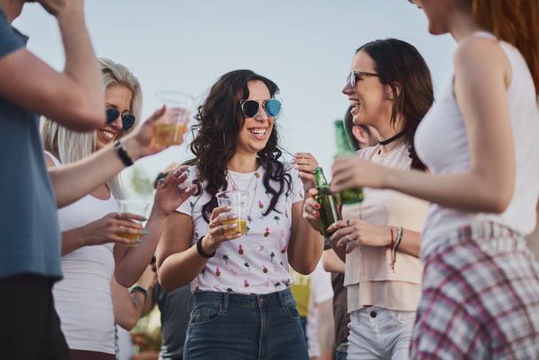 Gruppe von Menschen steht und trinkt beim Sommerfest im Freien  - Foto, Bild