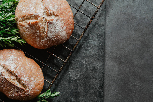 Pan recién horneado acostado en el estante de enfriamiento y ston negro con estilo
 - Foto, imagen