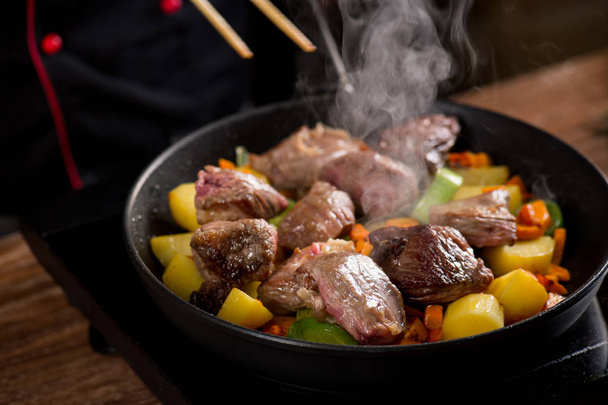 Koken van vlees en groenten op pan, close-up - Foto, afbeelding