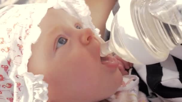 Mãe dando bebê menina para beber do frasco
 - Filmagem, Vídeo