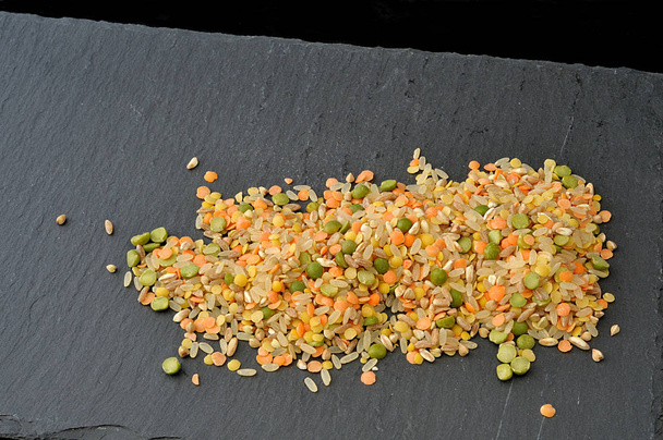 mezcla de arroz, legumbres, cebada, para sopa, cruda en plato de pizarra
 - Foto, imagen
