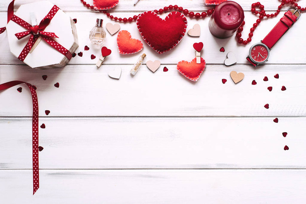 Fond de Saint Valentin avec des coeurs rouges, chevilles de vêtements, boîte et parfum sur fond de planches de bois
 - Photo, image