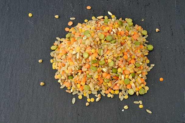 montón de cereales crudos y legumbres en un plato de pizarra
 - Foto, imagen