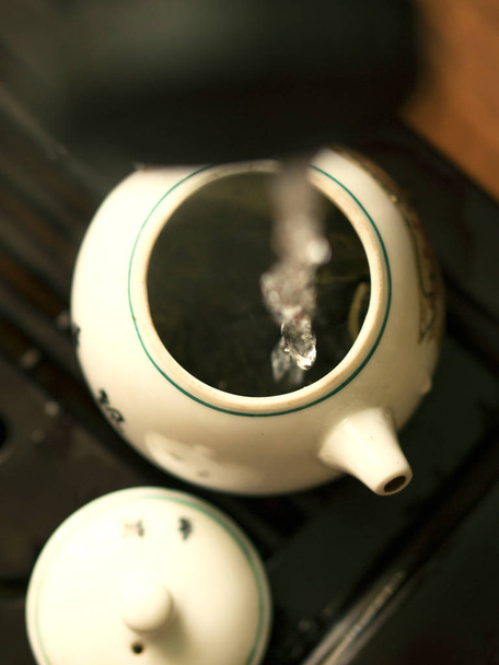 Заливки вишуканий зеленого чаю з чайника в традиційних китайських чайної церемонії. Встановити обладнання за чашкою чаю - Фото, зображення