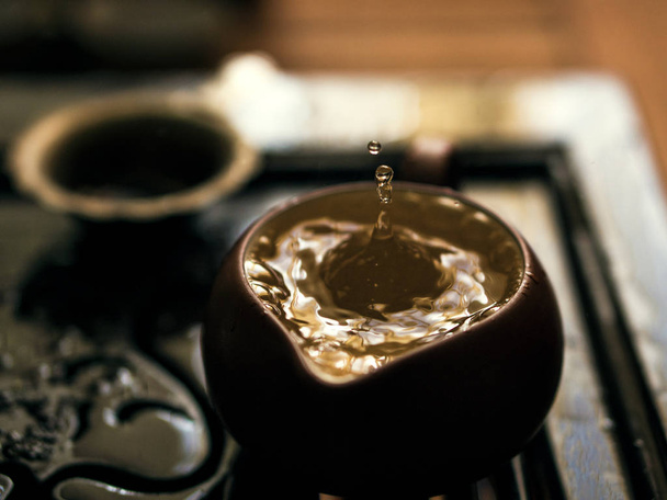 Заливки вишуканий зеленого чаю з чайника в традиційних китайських чайної церемонії. Встановити обладнання за чашкою чаю - Фото, зображення