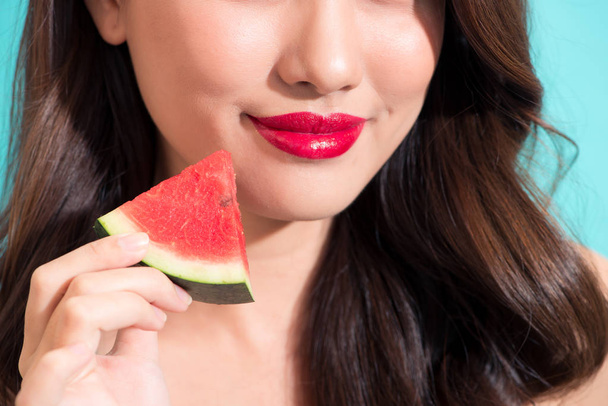 Closeup of beautiful girl with red lips eating watermelon. - Photo, Image